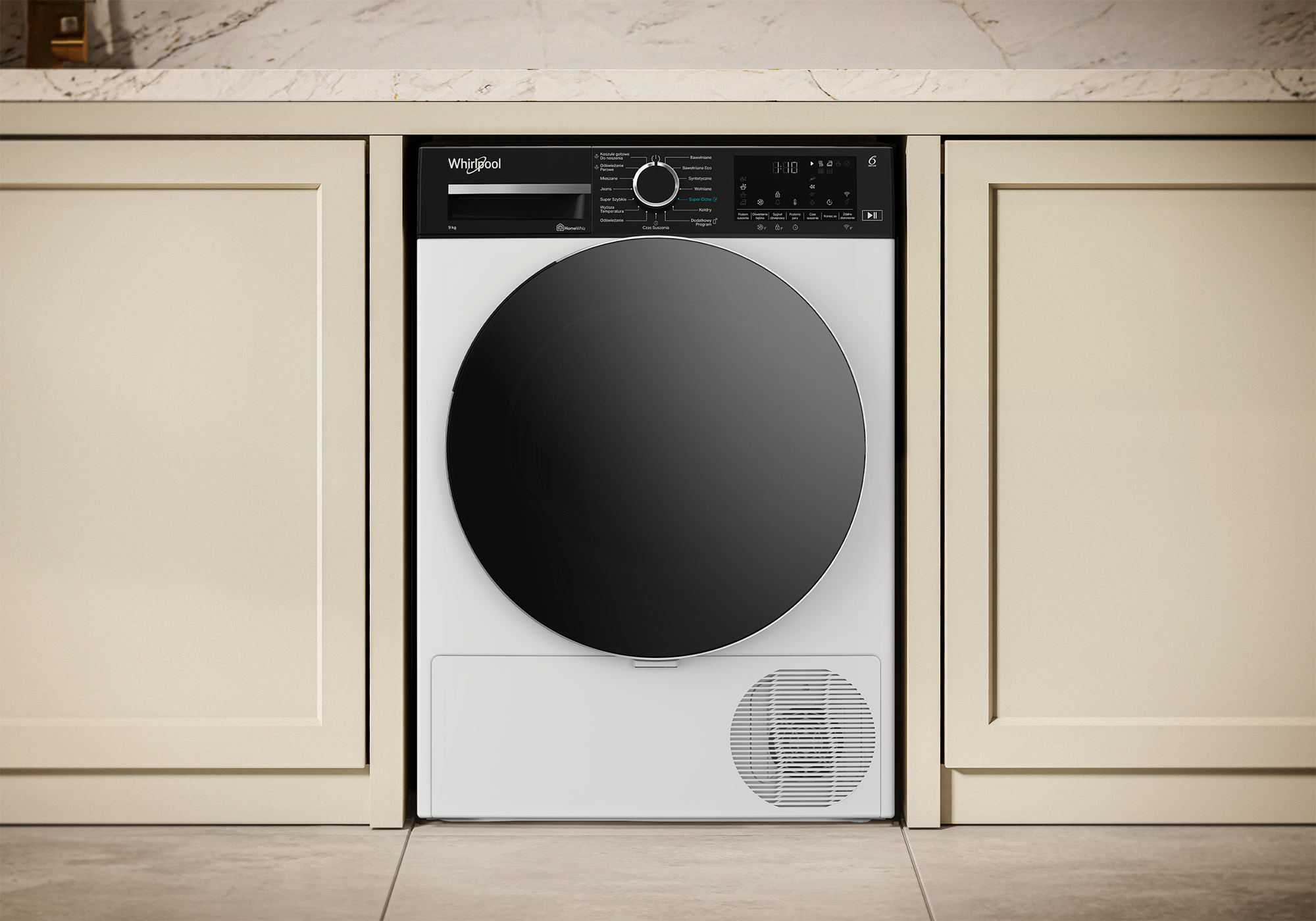 Biała suszarka Whirlpool jest wbudowana w szafkę. Ma czarne drzwi i panel sterowania. Otaczają ją beżowe szafki.