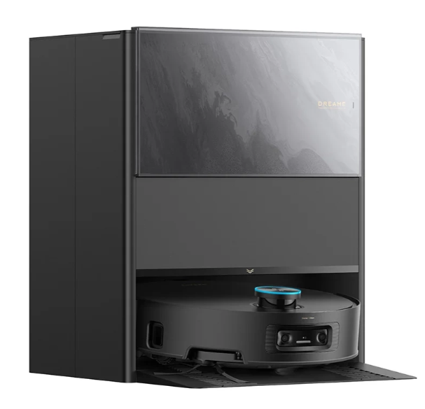 Czarny robot odkurzający w stacji ładującej. Stacja ma ciemnoszarą fasadę ze szklanymi drzwiami.