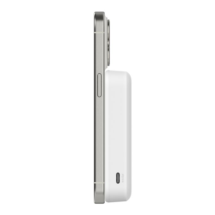 Vista lateral de un teléfono plateado con un cargador portátil blanco adjunto. El cargador tiene un botón de encendido y una etiqueta de entrada y salida.
