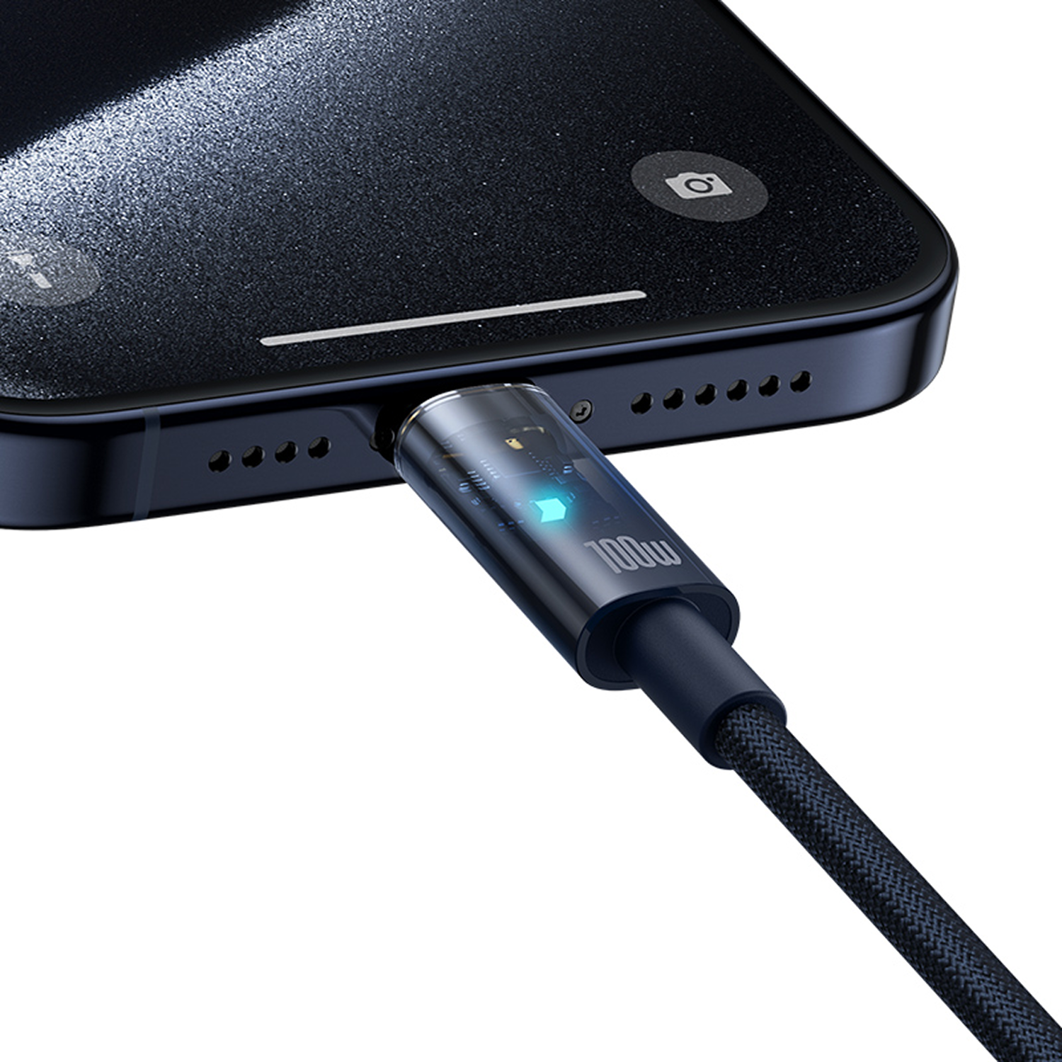 Un teléfono se está cargando con un cable USB-C. El teléfono es negro. El cable tiene una luz azul y dice 100W.