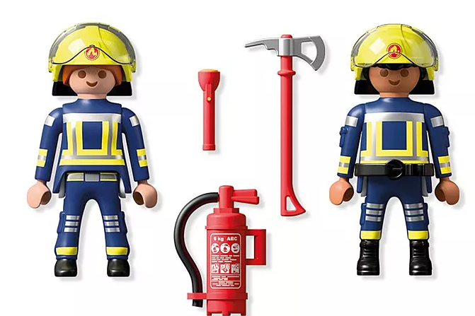 Zwei Spielzeug-Feuerwehrleute mit Helmen, Uniformen und Werkzeugen wie Taschenlampe, Axt und Feuerlöscher, isoliert auf Weiß.