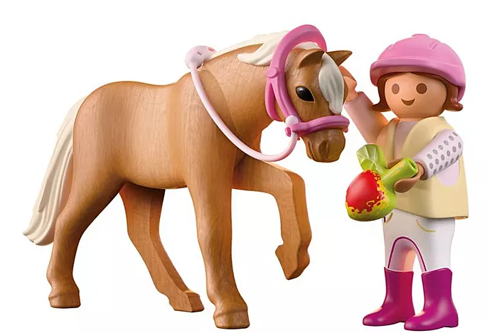 Ein Spielzeugpferd mit rosa Zaumzeug steht neben einer Figur eines Mädchens, das ein rot-grünes Objekt hält und einen rosa Helm trägt.