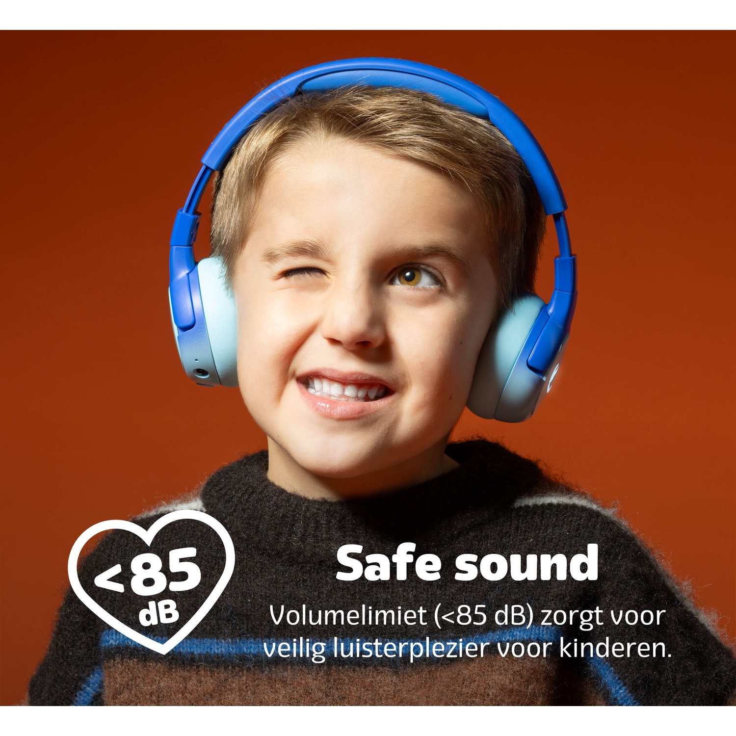 Een jongen met een blauwe koptelefoon knipoogt en lacht. Tekst: "Veilig geluid" en "<lt/>85 dB". Achtergrond is oranje.