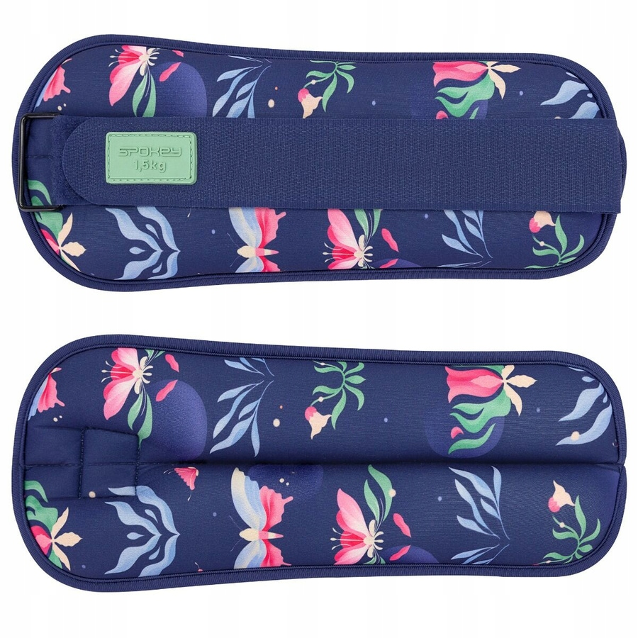 Dwa granatowe obciążniki na nadgarstki z kwiatowymi wzorami. Każdy ma pasek i zieloną etykietę z napisem 'Spokey 1,5kg'.