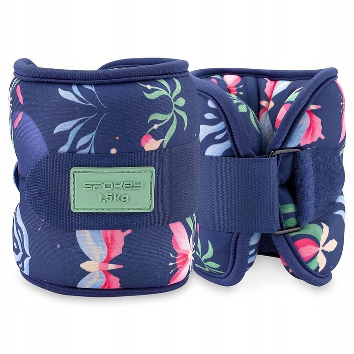 Dwa granatowe obciążniki na kostki w kwiaty. Każdy ma pasek i zieloną etykietę z napisem 'Spokey 1,5kg'.