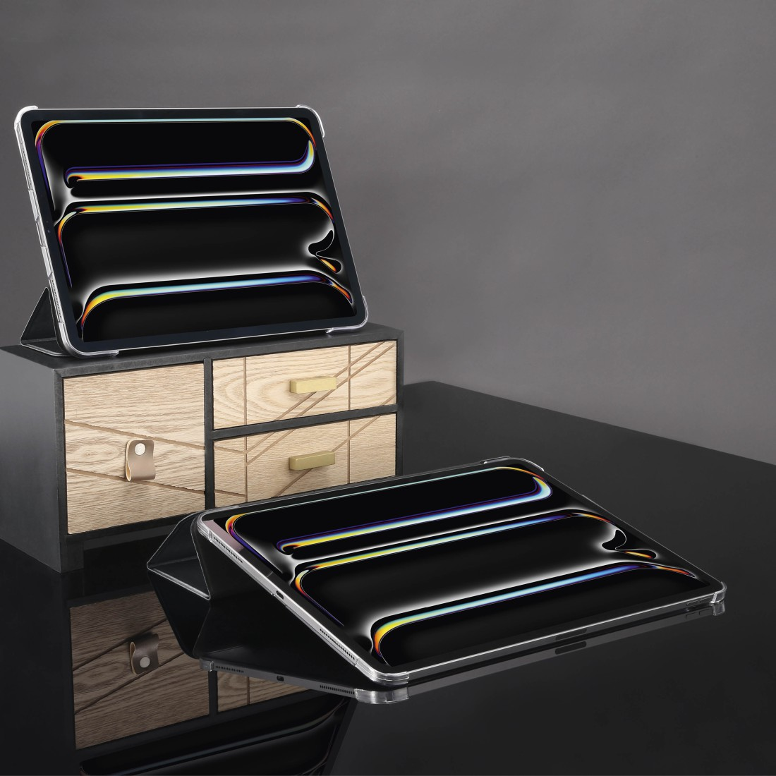 Zwei Tablets mit schwarzen Bildschirmen. Eines liegt auf einer Holzschublade, das andere auf einer reflektierenden Oberfläche.