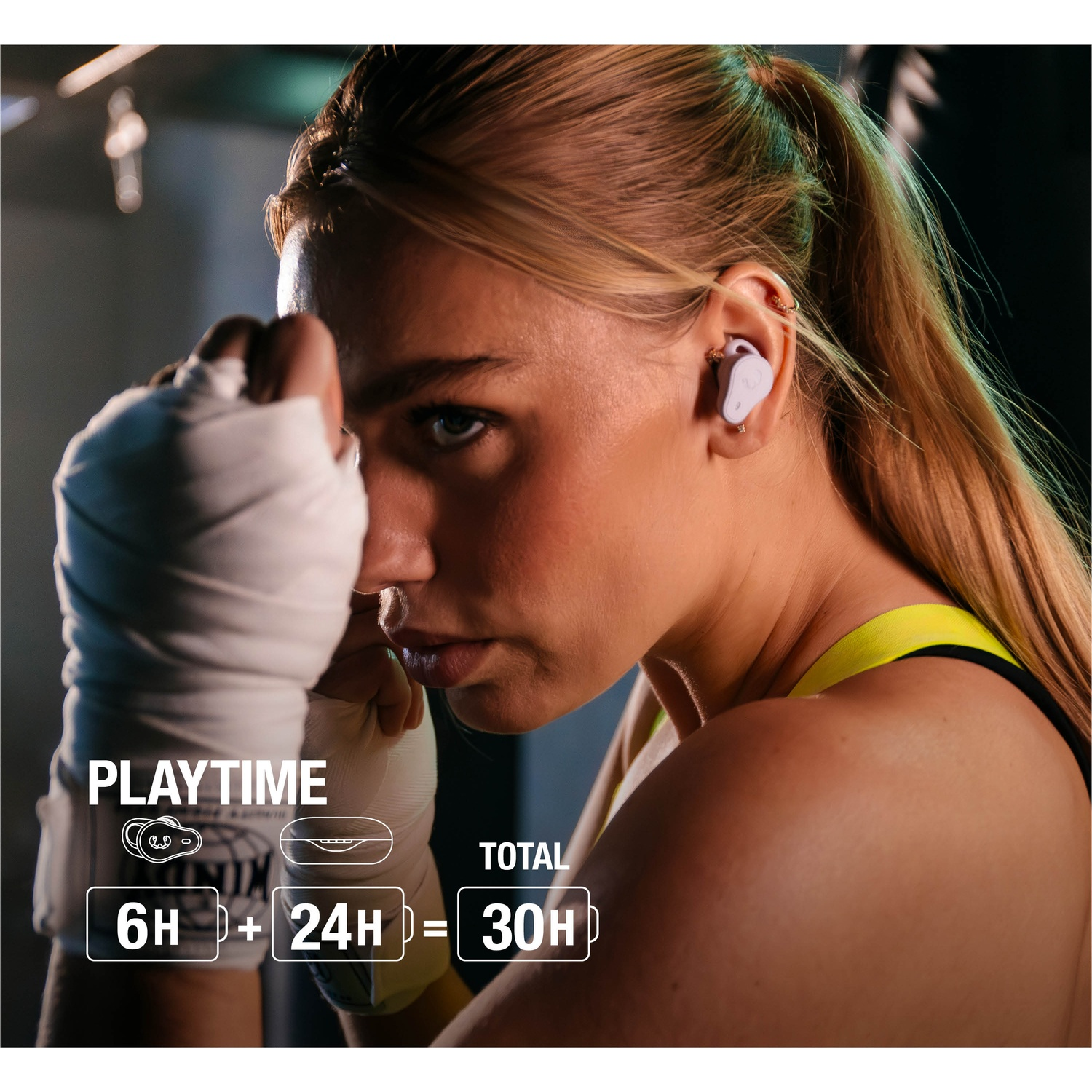 Een vrouw met blond haar en oordopjes staat klaar om te boksen, met witte handwraps. Tekst toont een totale speeltijd van 30 uur.