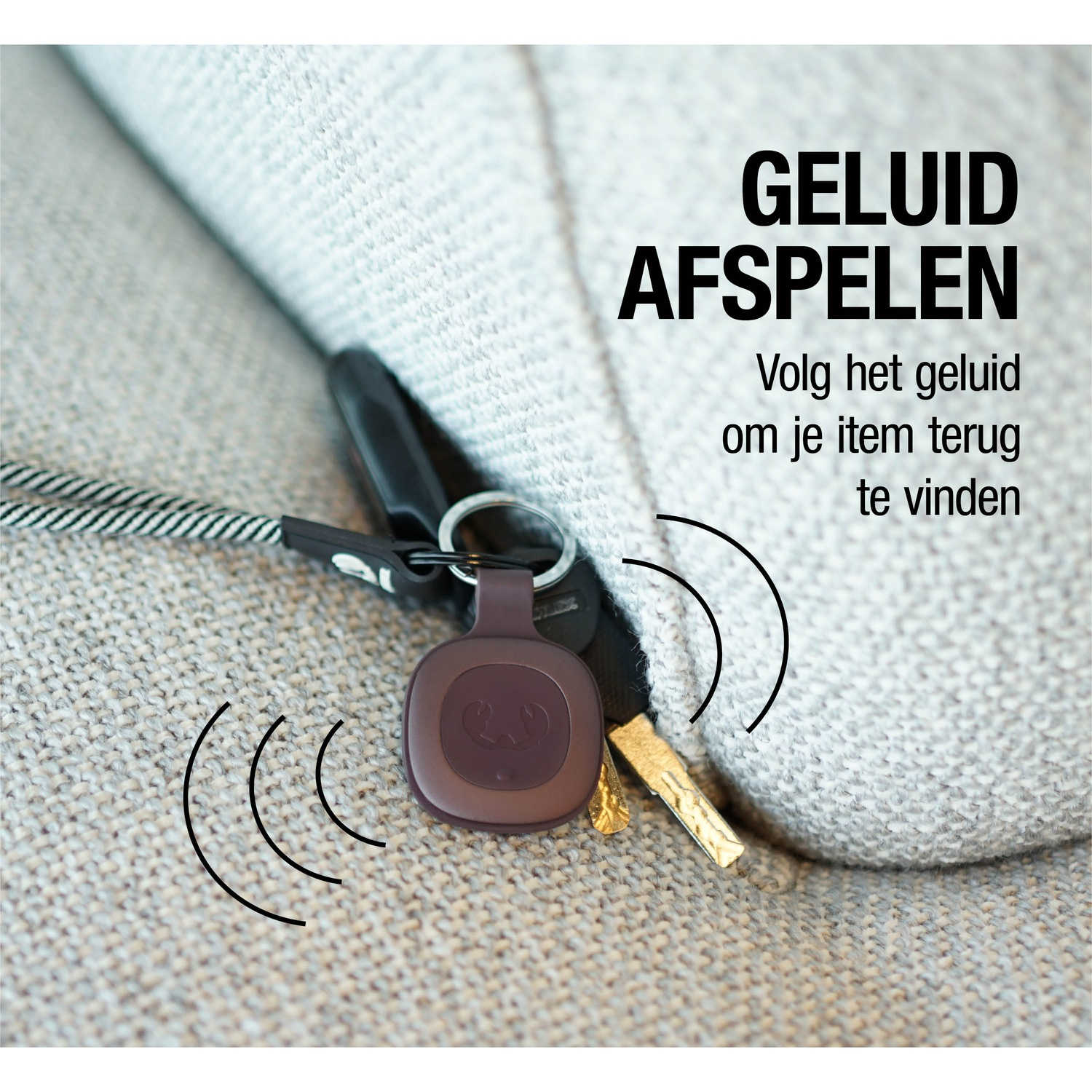 A key finder with keys attached, next to a fabric. The key finder is brown, and the keys are black. Text says 'Play sound'.