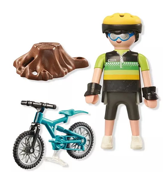 Eine Spielfigur mit Fahrrad und Baumstumpf. Die Figur trägt Helm, Brille und Radbekleidung. Das Fahrrad ist türkis.