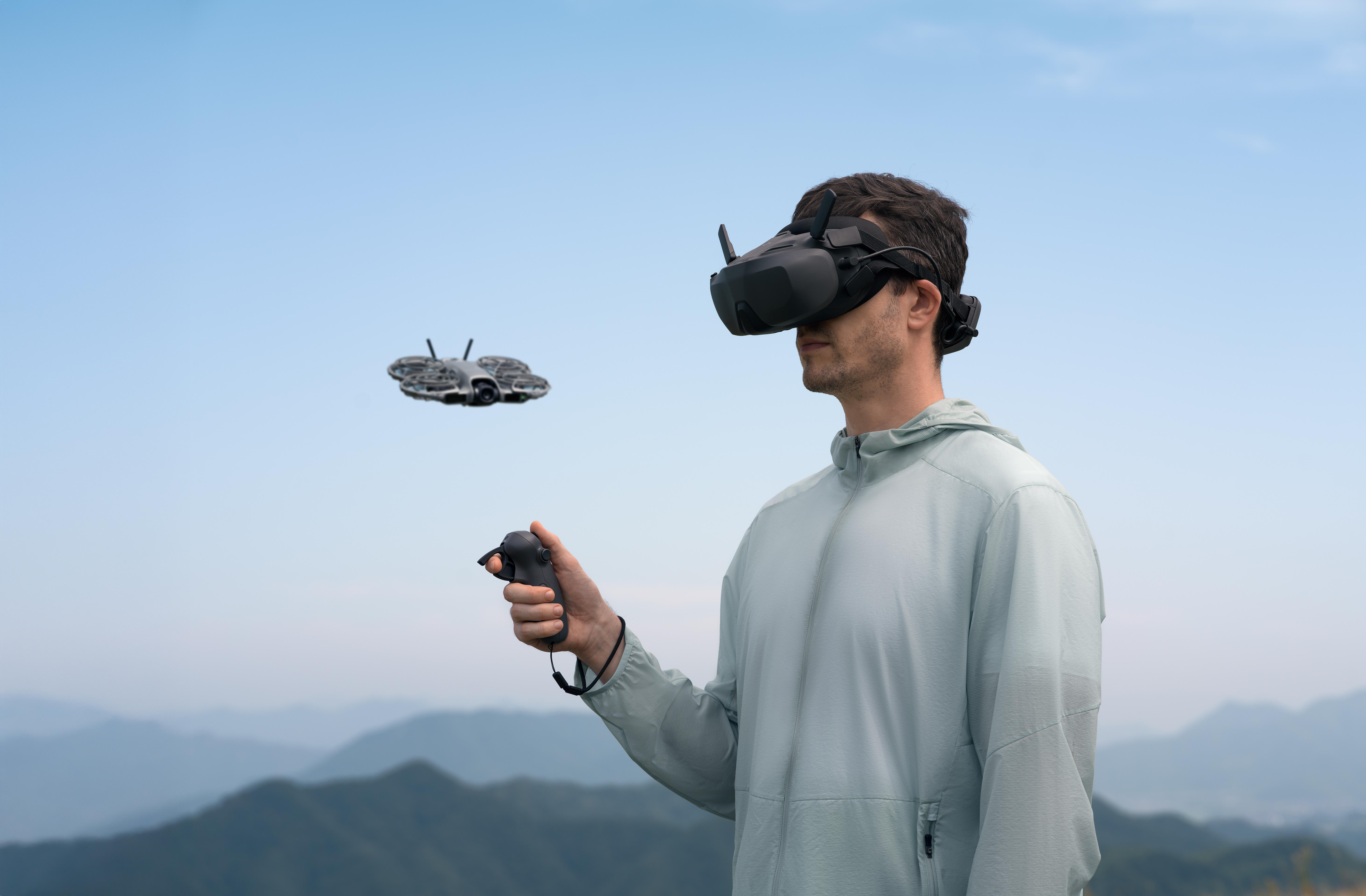 Mann mit VR-Headset und Controller, Drohne fliegt, Bergblick.