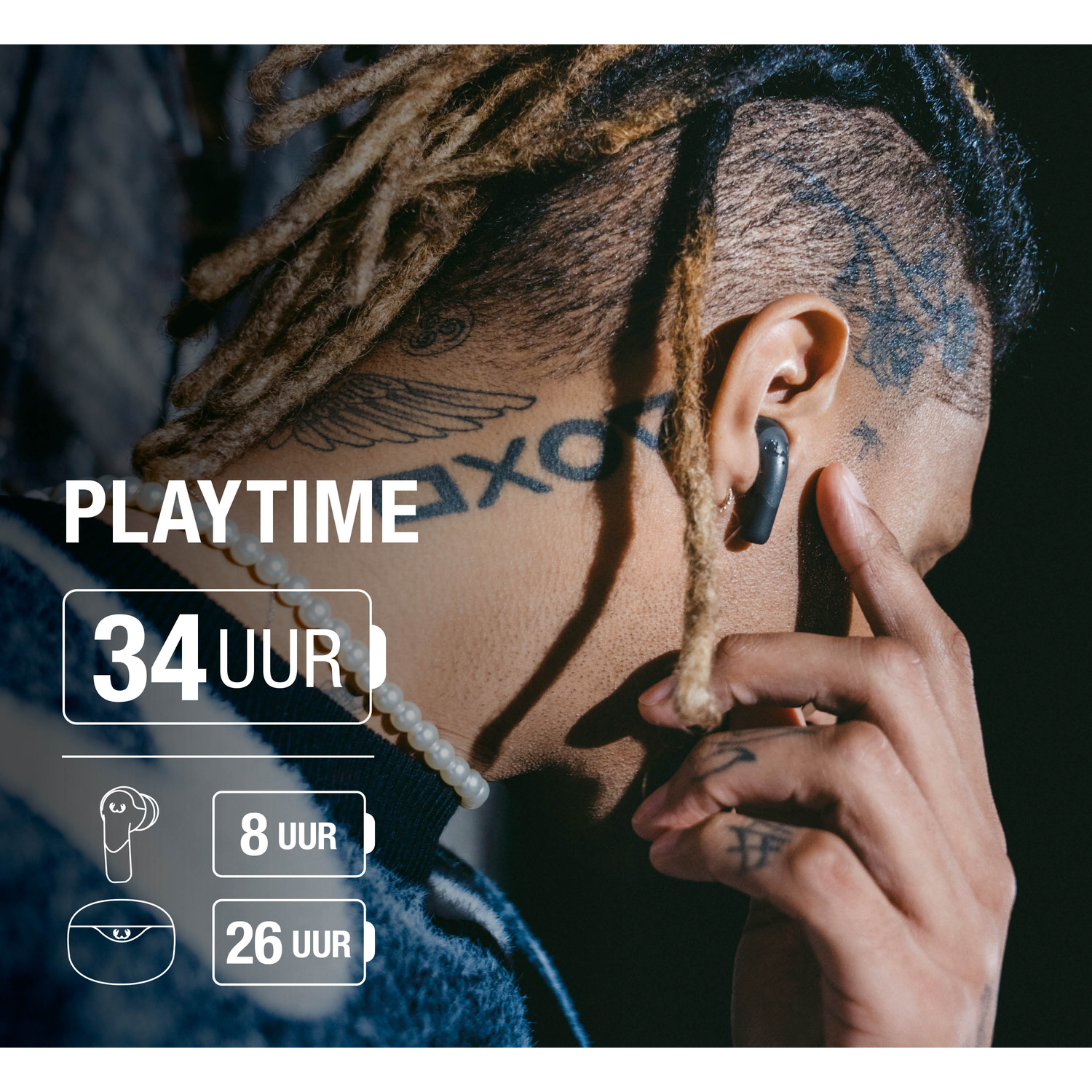 A person with dreadlocks wearing earbuds. Text overlay: Playtime 34 uur. Additional details about battery life are also present.