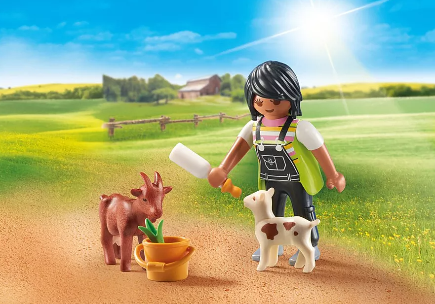 Eine Playmobil-Figur mit Tieren. Eine Person, die eine Flasche hält, steht auf einem Feld mit einer Ziege und einem Lamm. Im Hintergrund ist eine Scheune zu sehen.