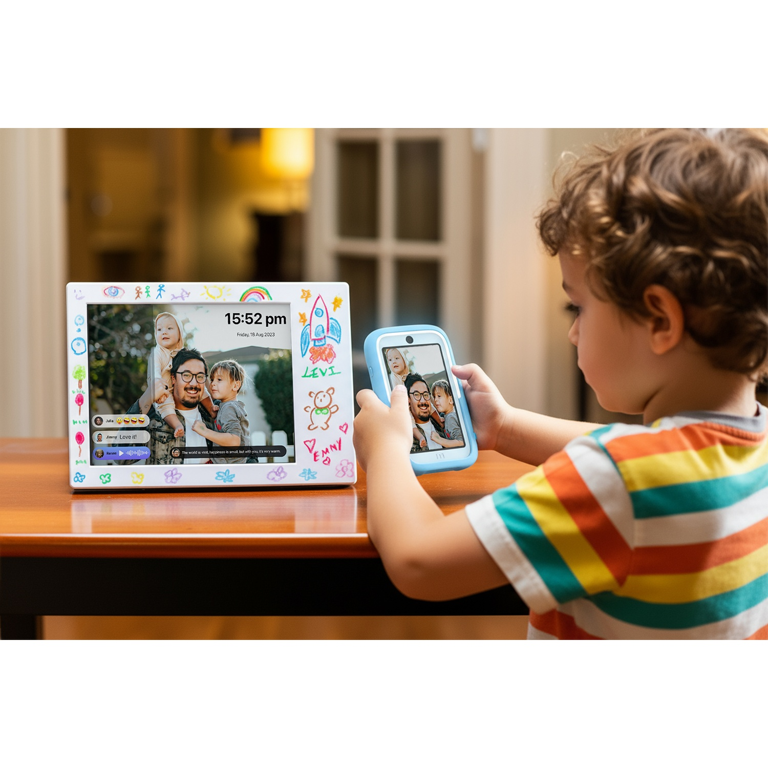 Un bambino tiene in mano un tablet che riflette una cornice su un tavolo. Entrambi mostrano una famiglia. La cornice è decorata con disegni.