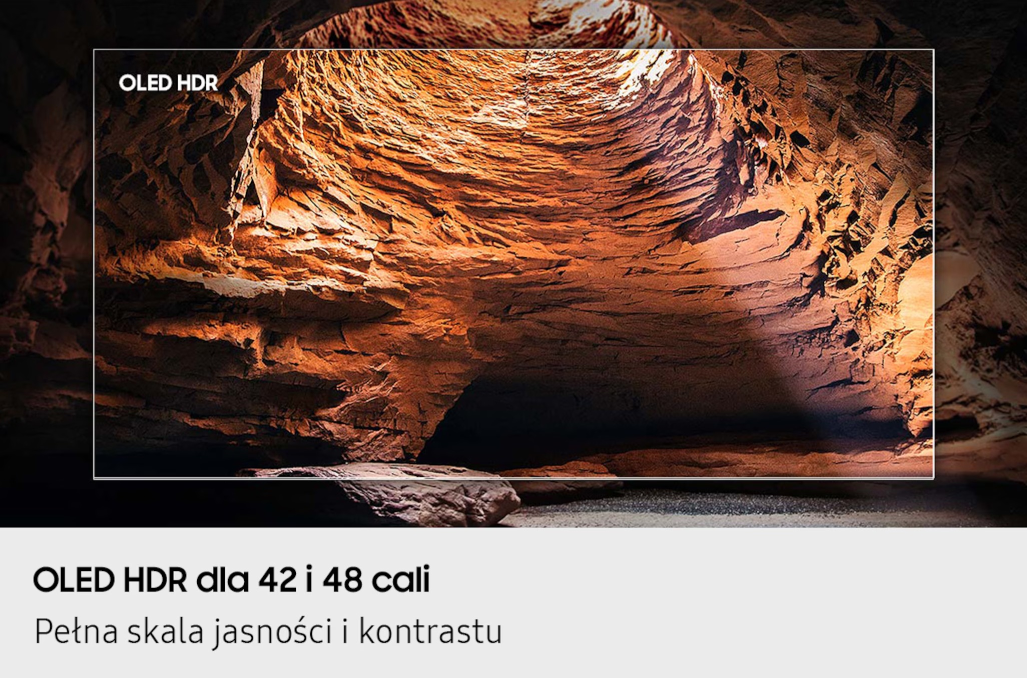 Obraz przedstawia wnętrze jaskini, oświetlone od góry, z chropowatymi, pomarańczowo-brązowymi formacjami skalnymi. Widoczny tekst OLED HDR. Tekst na dole brzmi: OLED HDR dla 42 i 48 cali.