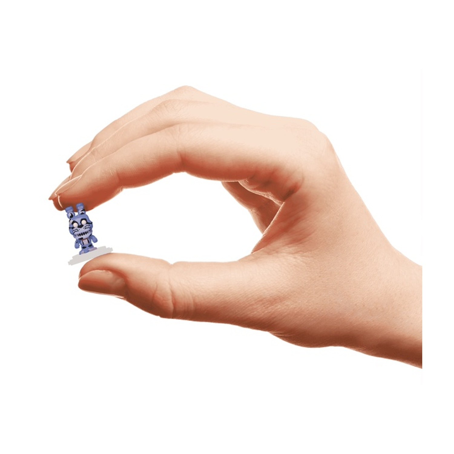 Una mano tiene un piccolo coniglio giocattolo blu. La figura del coniglio ha denti bianchi ed è su una piccola piattaforma bianca.