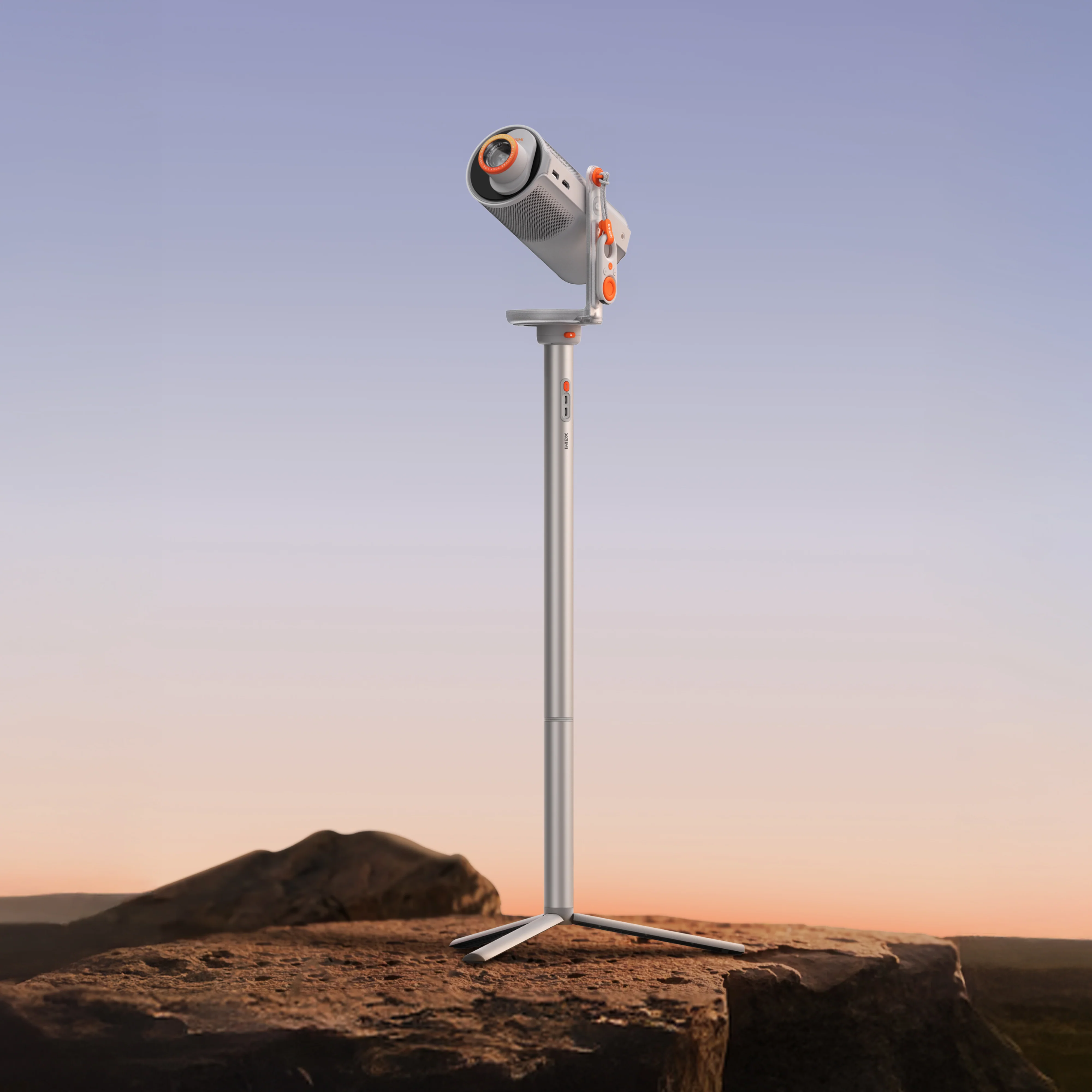 Un projecteur sur un support sur un rocher, avec un fond de coucher de soleil.