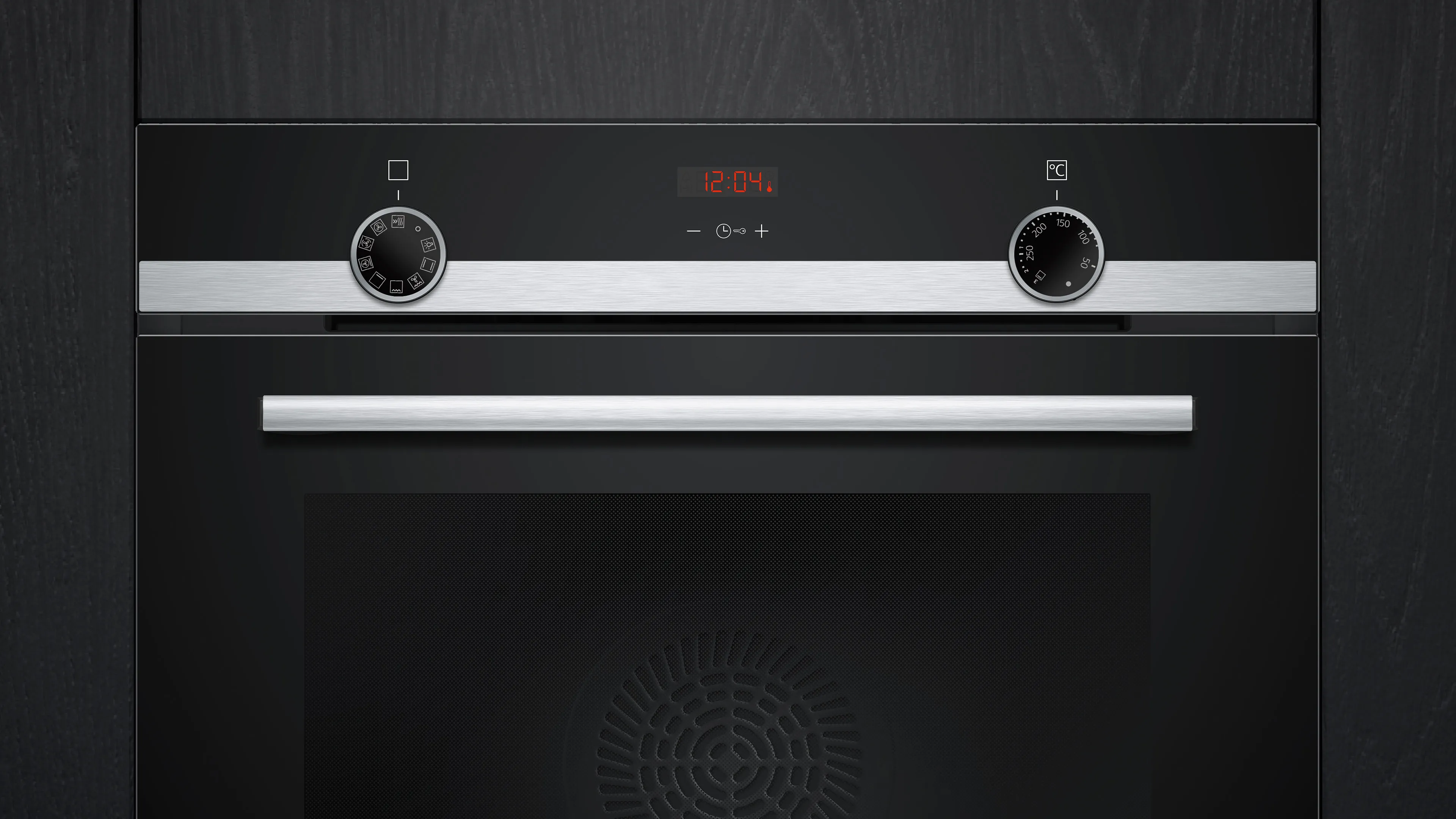 Primer plano de un horno negro. Tiene un reloj digital que muestra las 12:04. Se ven perillas y un asa.