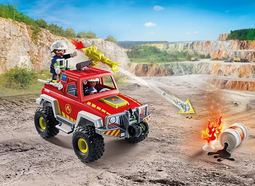 Roter Feuerwehrauto mit zwei Figuren, gelbem Strahl und Feuer vorne. Im Hintergrund ist ein Steinbruch.