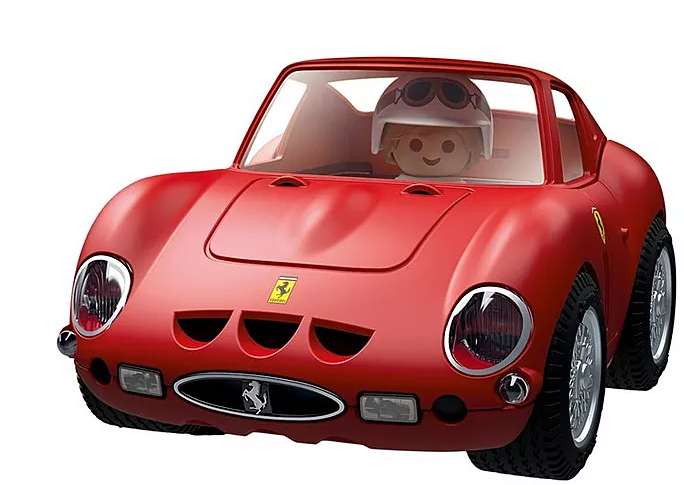 Ein roter Spielzeug-Ferrari mit einem Fahrer, der einen weißen Helm und eine Brille trägt. Das Auto hat schwarze Reifen und silberne Felgen.