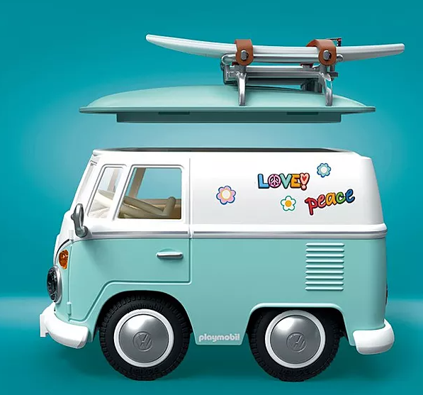Ein blaugrüner und weißer Spielzeug-Van mit Surfbrett. Es hat 'Love & Peace'-Aufkleber und ein VW-Logo auf den Rädern.