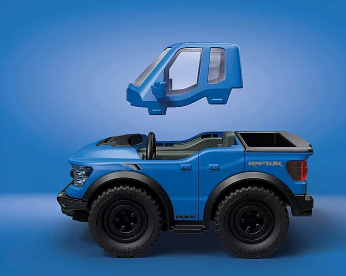 Blauer Spielzeug-Ford Raptor mit abnehmbarem Dach auf blauem Hintergrund. Schwarze Räder, Spielzeuglenkrad. Playmobil-Logo.