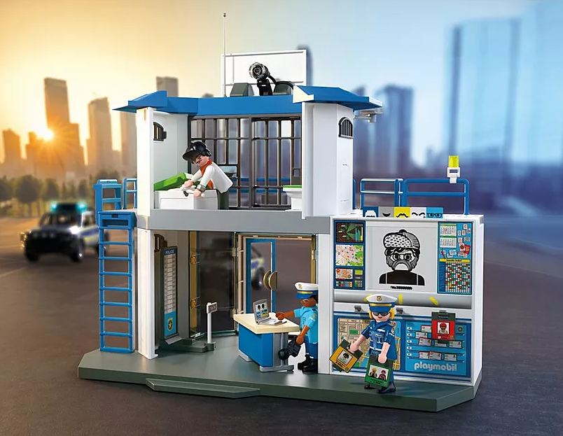 Ein Playmobil-Polizeistationsset. Figuren von Polizisten und einem Gefangenen sind zu sehen. Im unscharfen Hintergrund ist ein Polizeiauto zu sehen.