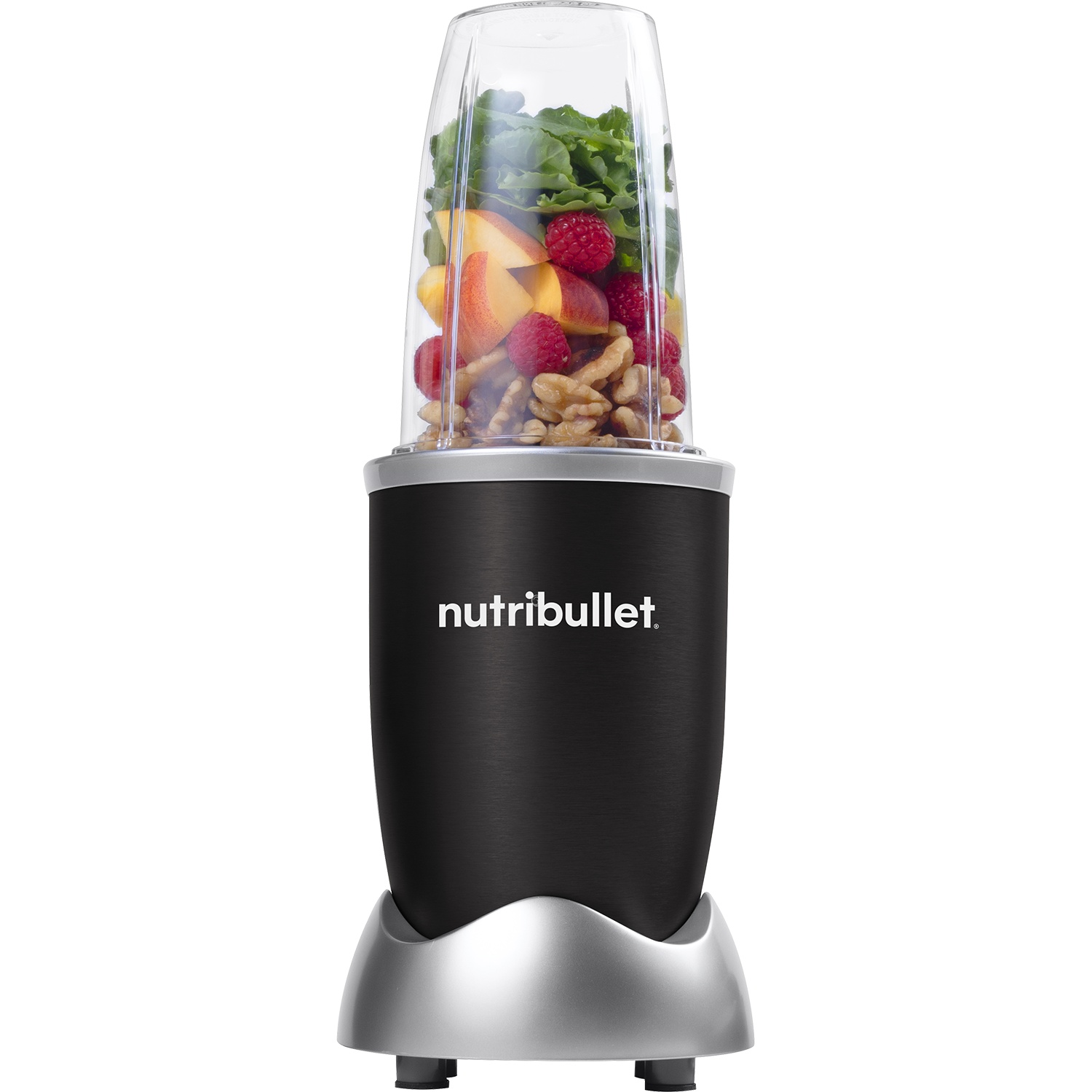 A Nutribullet blender with ingredients inside. It contains fruit, nuts, and greens. The base is black and silver.