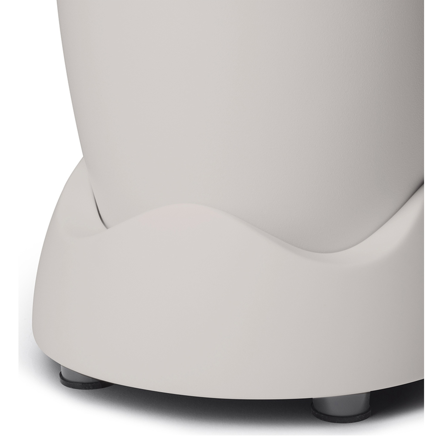 Close-up of a white, rounded object with a curved base and small gray feet. The object appears to be a part of a larger structure.
