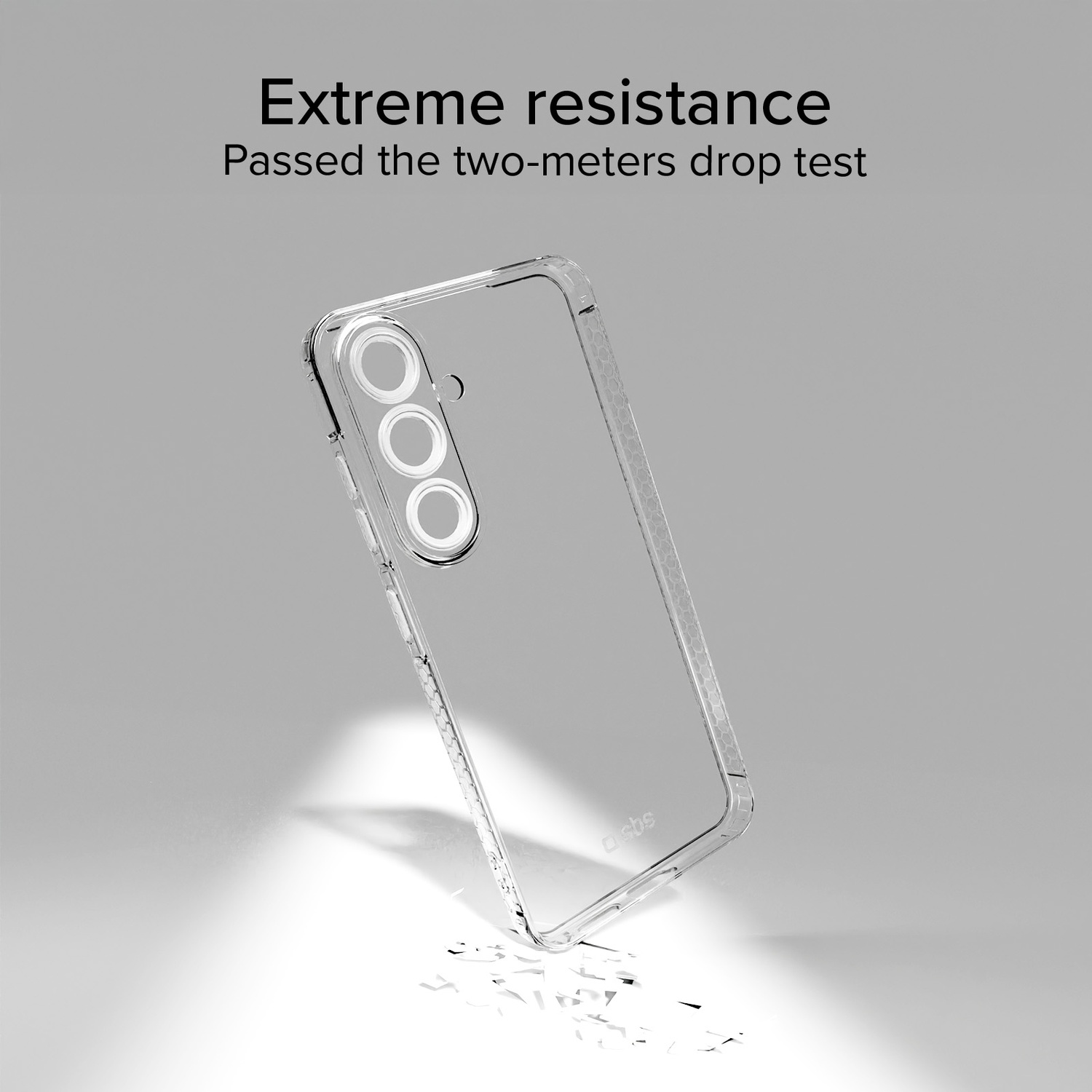 Une coque de téléphone transparente montre trois cercles de caméra. Le texte ci-dessus indique 'Résistance extrême'. La coque est inclinée sur une surface gris clair.