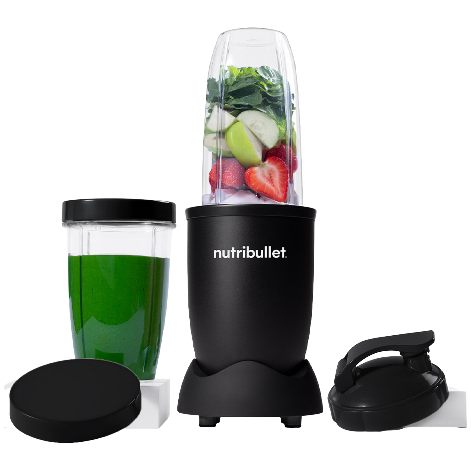 Een zwarte Nutribullet blender met ingrediënten. Een glas met groene vloeistof en een deksel links. Een zwarte handgreep rechts.