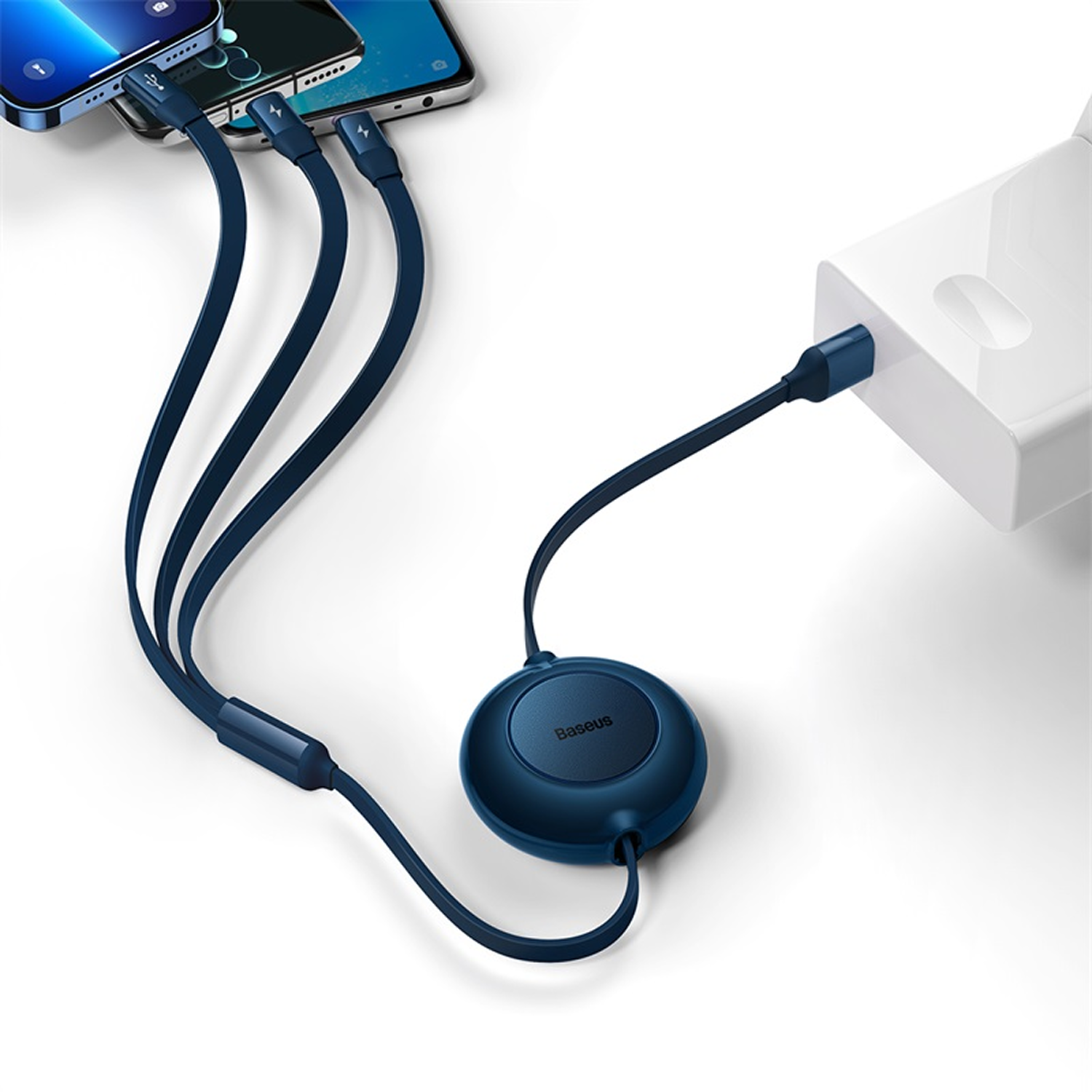 Cable azul Baseus multicargador conectado a teléfonos y un adaptador de corriente blanco. El cable tiene un concentrador redondo.