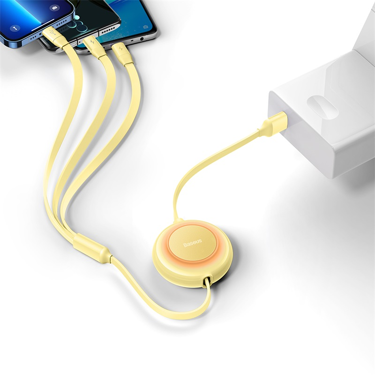 La imagen muestra tres teléfonos conectados a un cable de carga múltiple amarillo enchufado a un adaptador de corriente blanco.