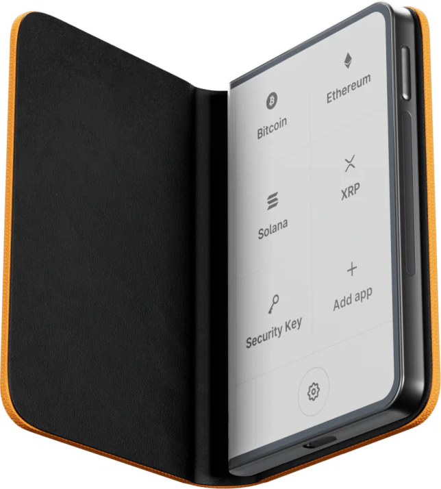 Geöffnete Wallet zeigt Kryptowährungsoptionen. Bitcoin, Ethereum, Solana, XRP und Sicherheitsschlüssel sind aufgelistet. Das Gehäuse ist orange und schwarz.