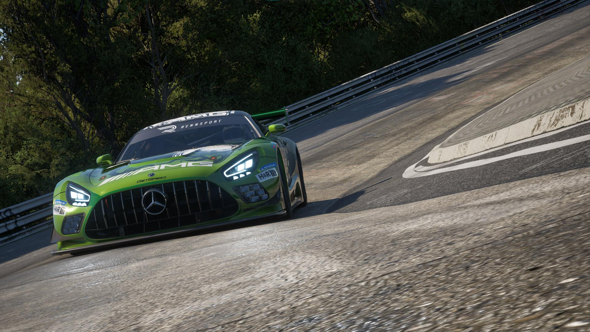 Ein grüner AMG Mercedes-Rennwagen fährt mit hoher Geschwindigkeit um eine kurvige Rennstrecke. Bäume säumen den Hintergrund.