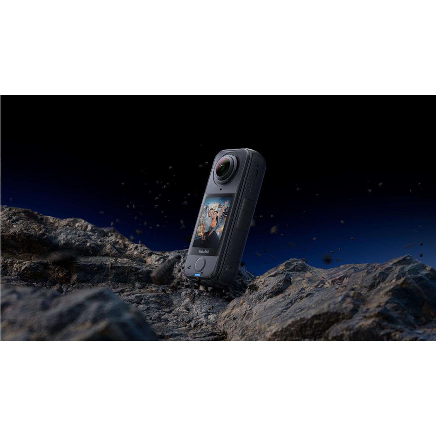 Una fotocamera Insta360 nera fluttua sopra delle rocce. Lo schermo mostra persone. Lo sfondo è blu scuro con piccole particelle.