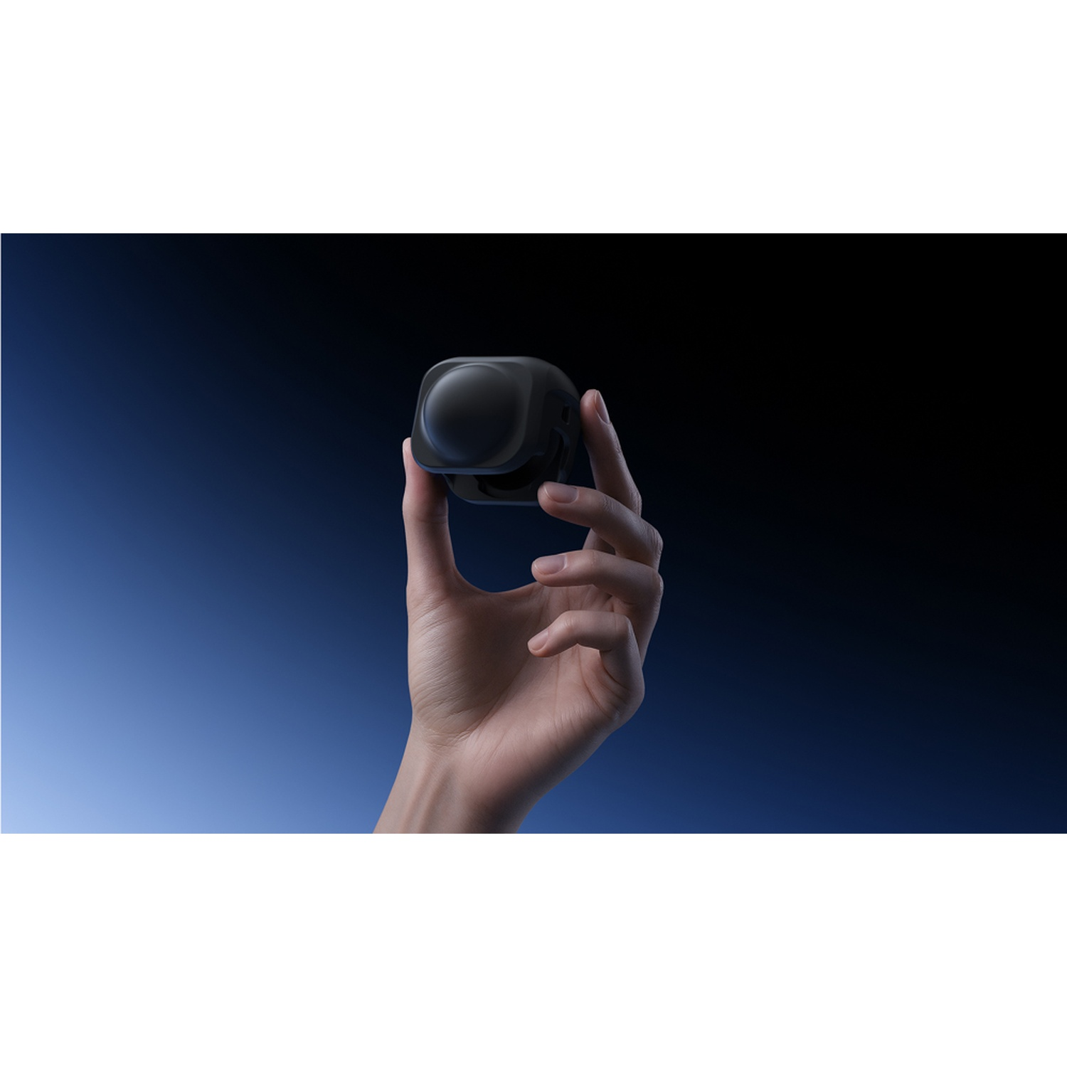 Una mano tiene un dispositivo nero a forma di cubo su uno sfondo sfumato blu-nero. Il dispositivo ha una parte superiore arrotondata.