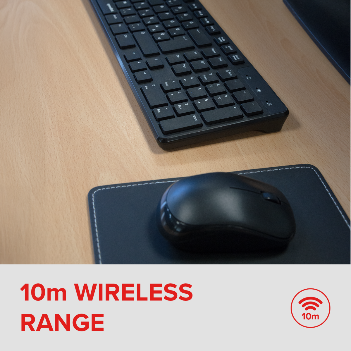 Fekete billentyűzet és egér egy fa asztalon. Az egérpad az egér alatt van. A szöveg 10m Wireless Range.