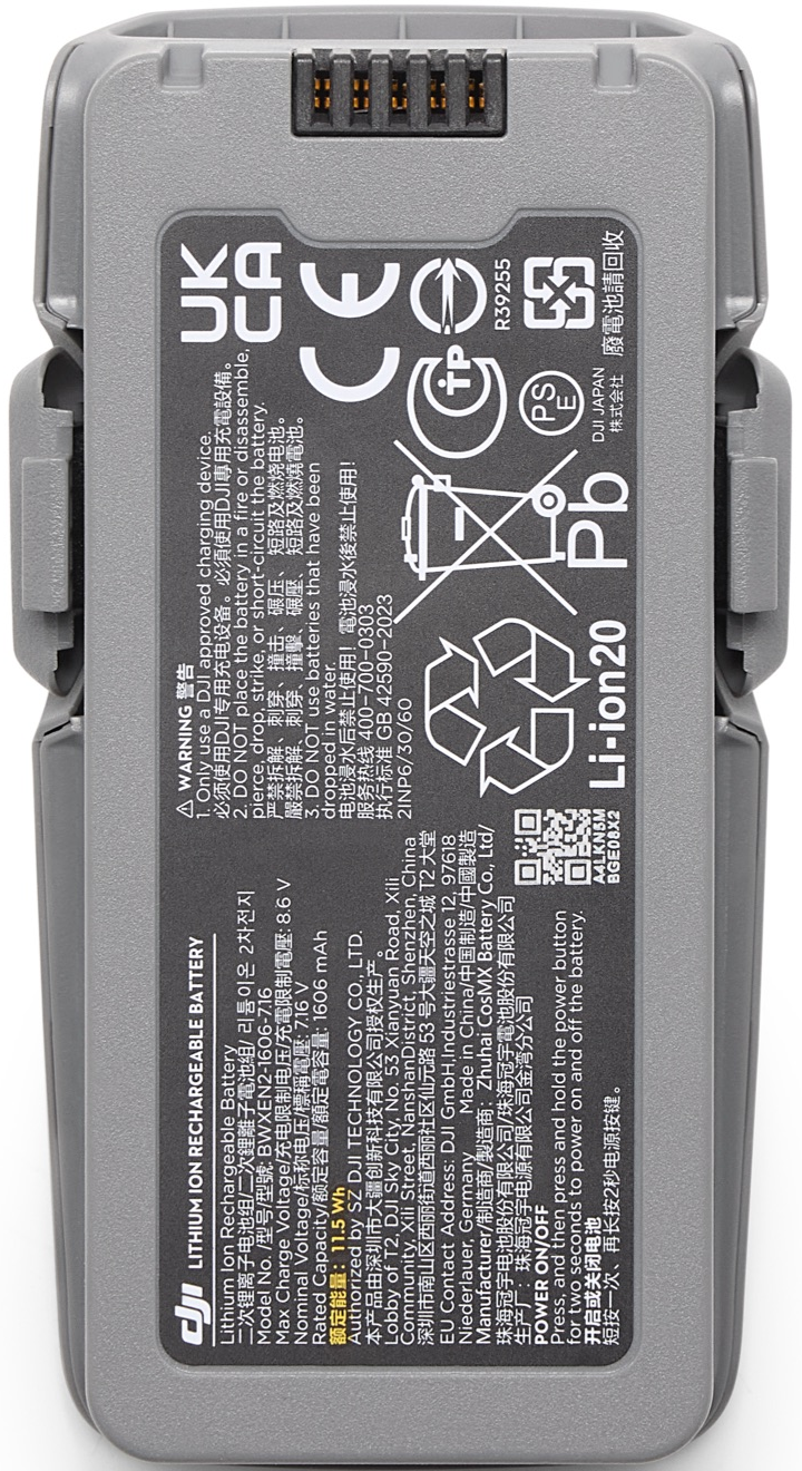 Une batterie de drone DJI grise avec des étiquettes d'avertissement et du texte. Comporte un symbole de recyclage et des informations.