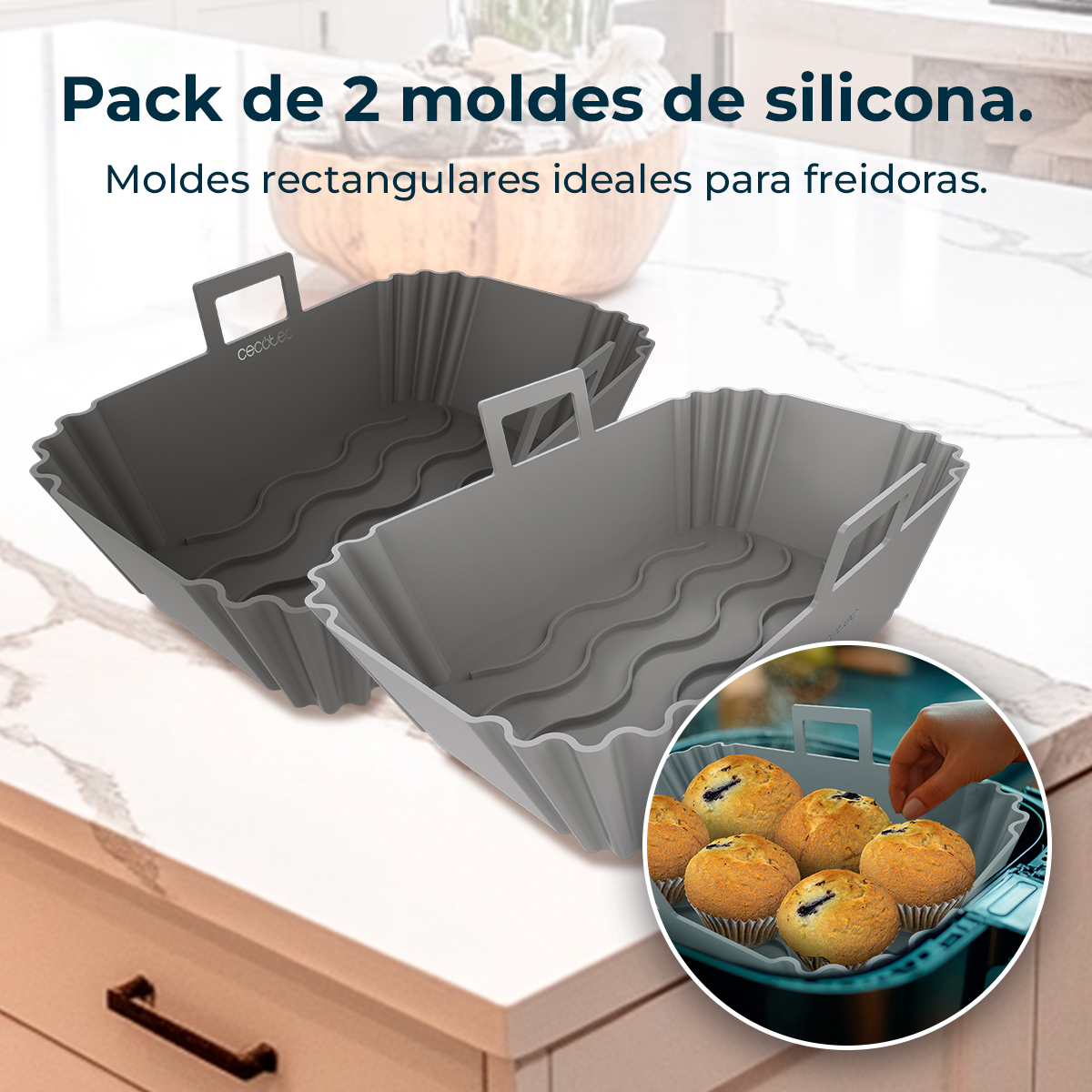 Dos moldes de silicona grises para freidoras. Uno gris oscuro, otro gris claro. Una mano coloca un muffin en un molde similar lleno de muffins.