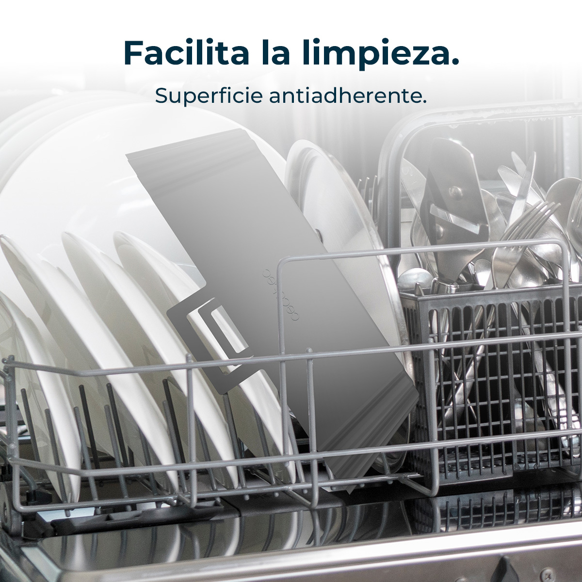 Interior de lavavajillas con platos y cubiertos limpios. Platos blancos, sartenes grises y cubiertos de plata ordenados en rejillas.