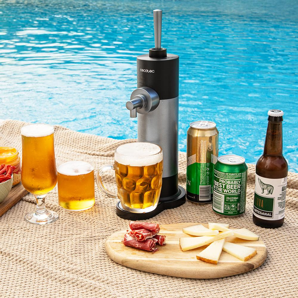 Vasos de cerveza, latas y un grifo están cerca de una piscina. Queso y carne están en una tabla de madera. La escena es brillante y soleada.