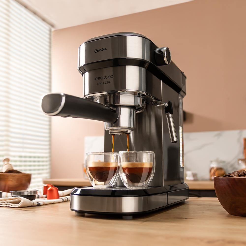 Máquina de espresso preparando café en dos tazas de vidrio. Mesa de madera con granos y accesorios. Fondo neutro.