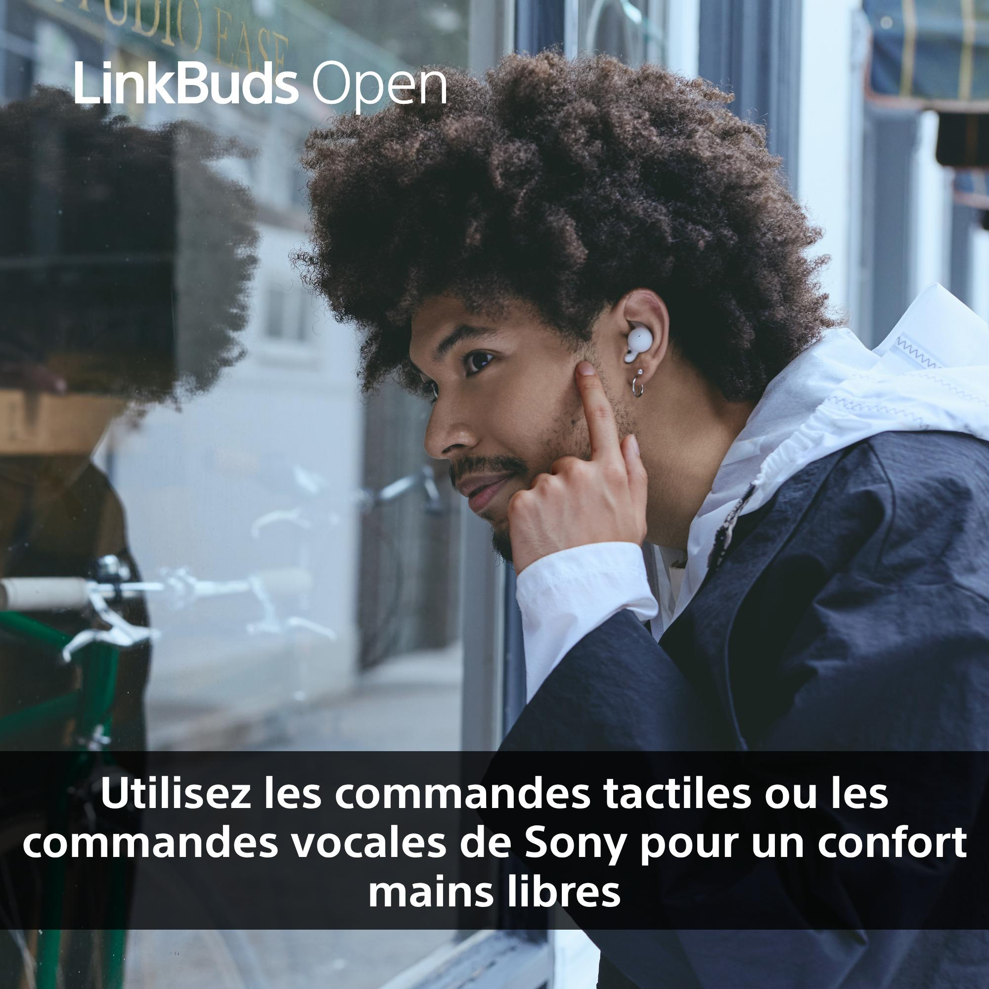 Un homme avec des écouteurs regarde par une fenêtre. Texte: 'Utilisez les commandes tactiles ou vocales pour un confort mains libres.'