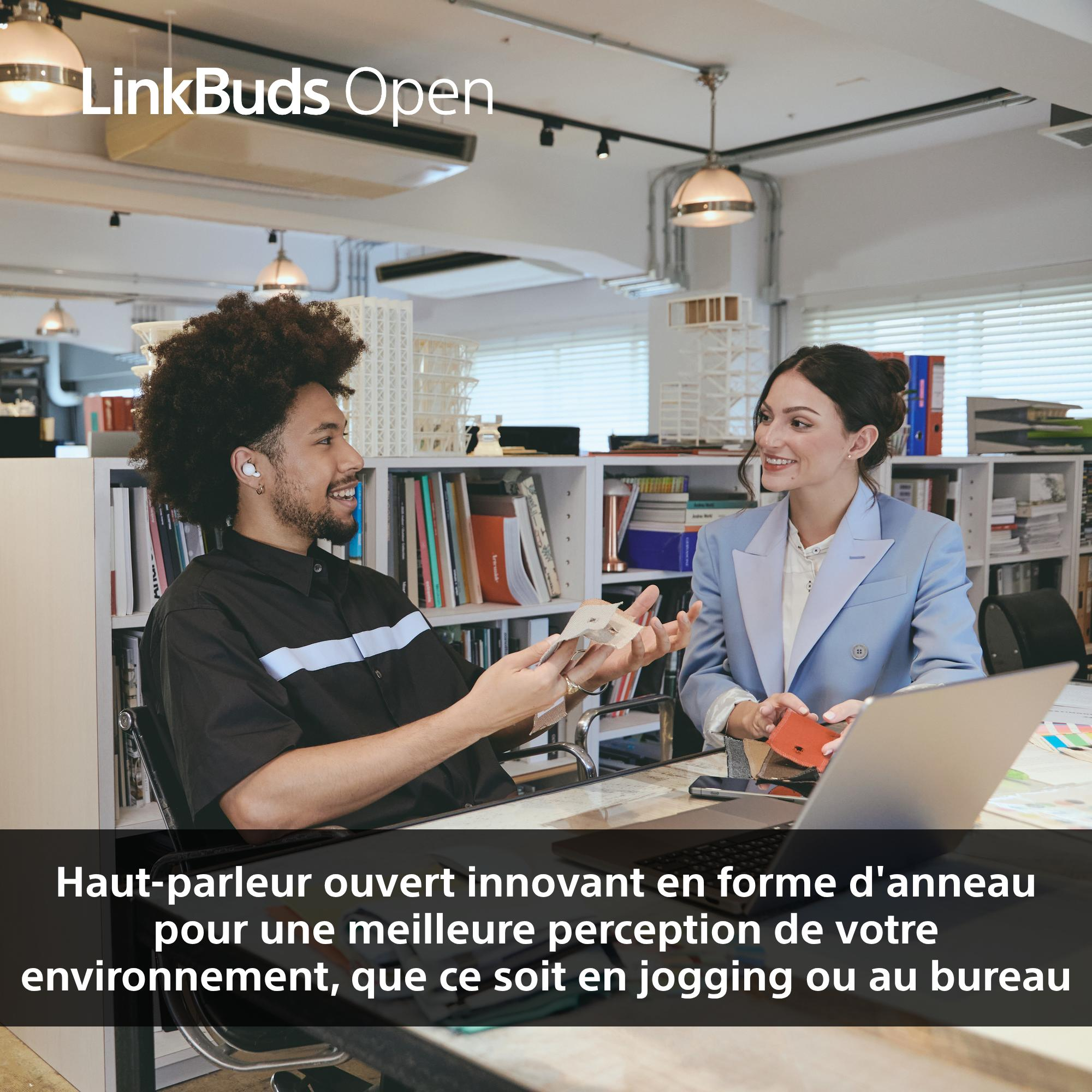 Deux personnes dans un bureau. L'une tient des échantillons de tissu, l'autre porte des écouteurs.