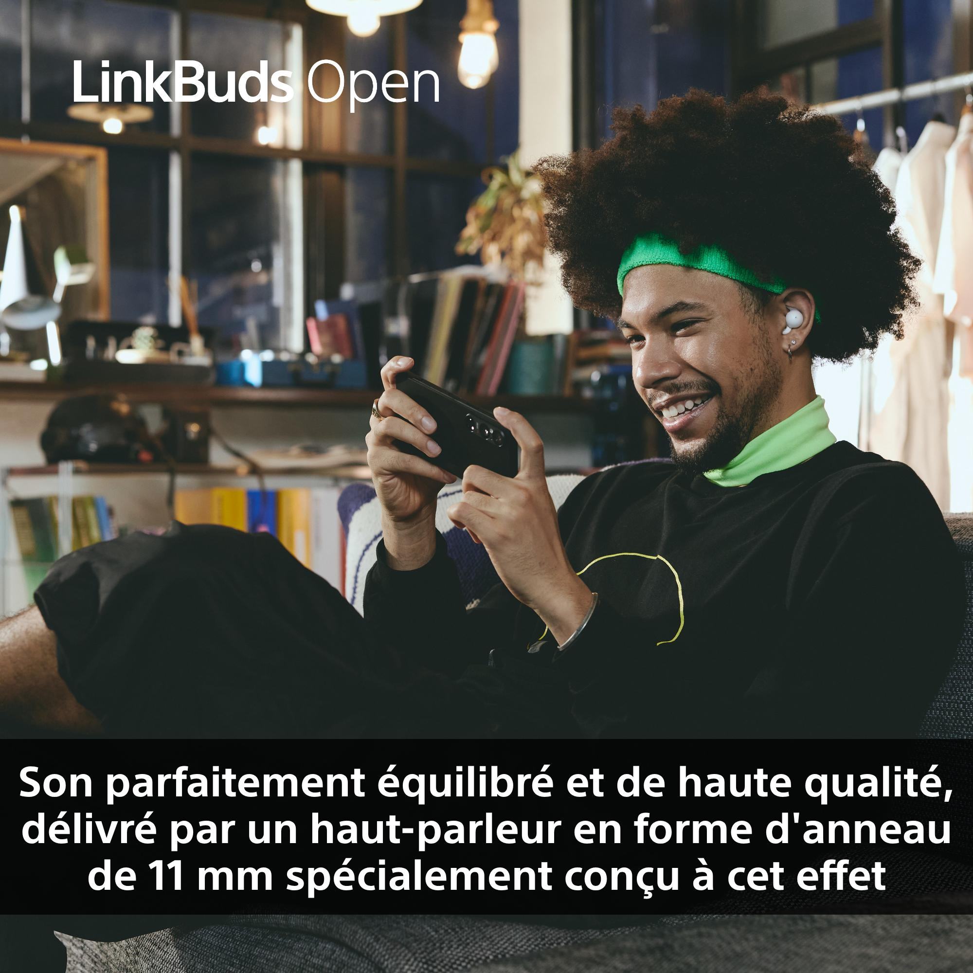Un homme portant des écouteurs et un bandeau, tenant un téléphone et souriant. Le texte dit 'LinkBuds Open'.