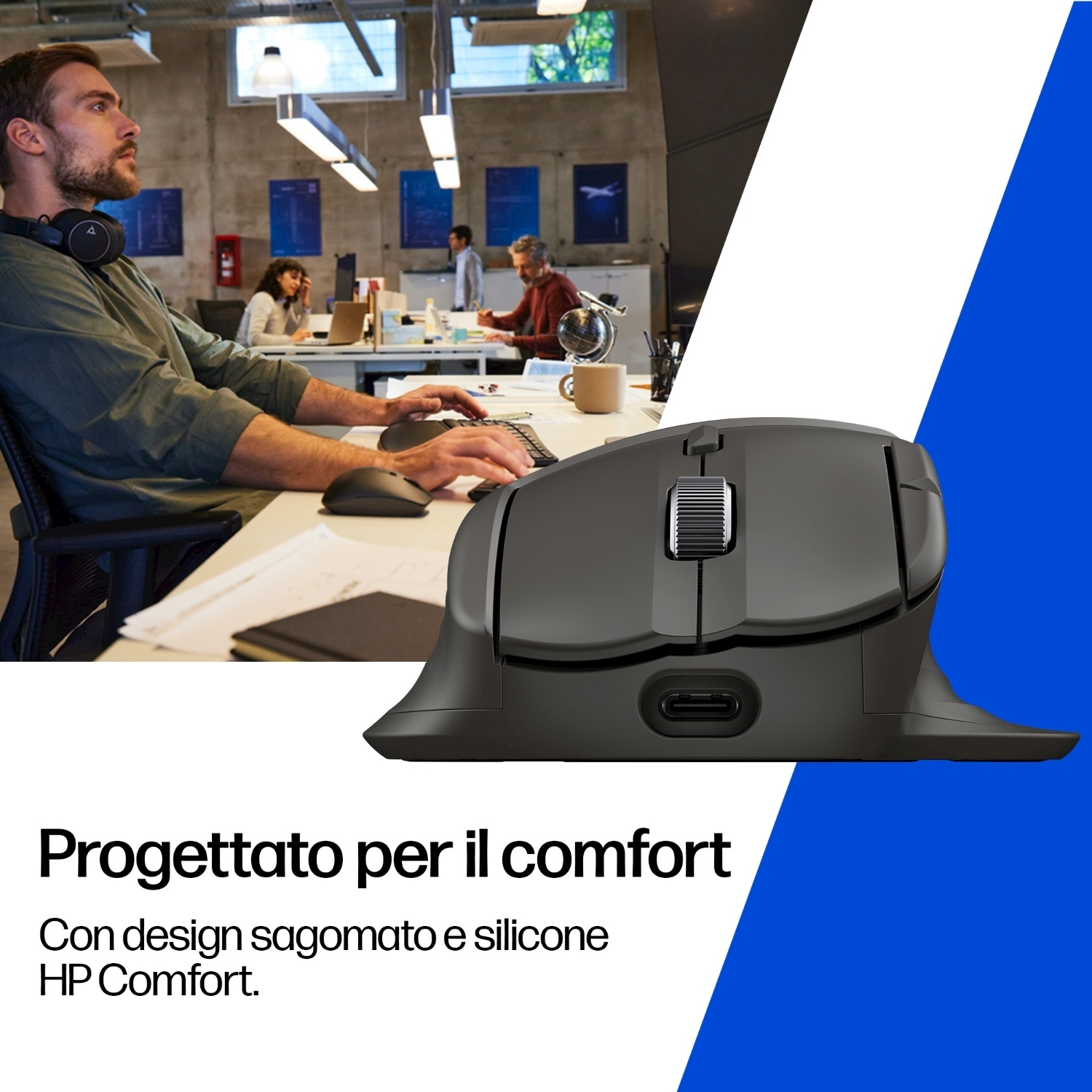 Un uomo usa una tastiera e un mouse in un ufficio. Un mouse nero è in primo piano. Altre persone sono sullo sfondo.