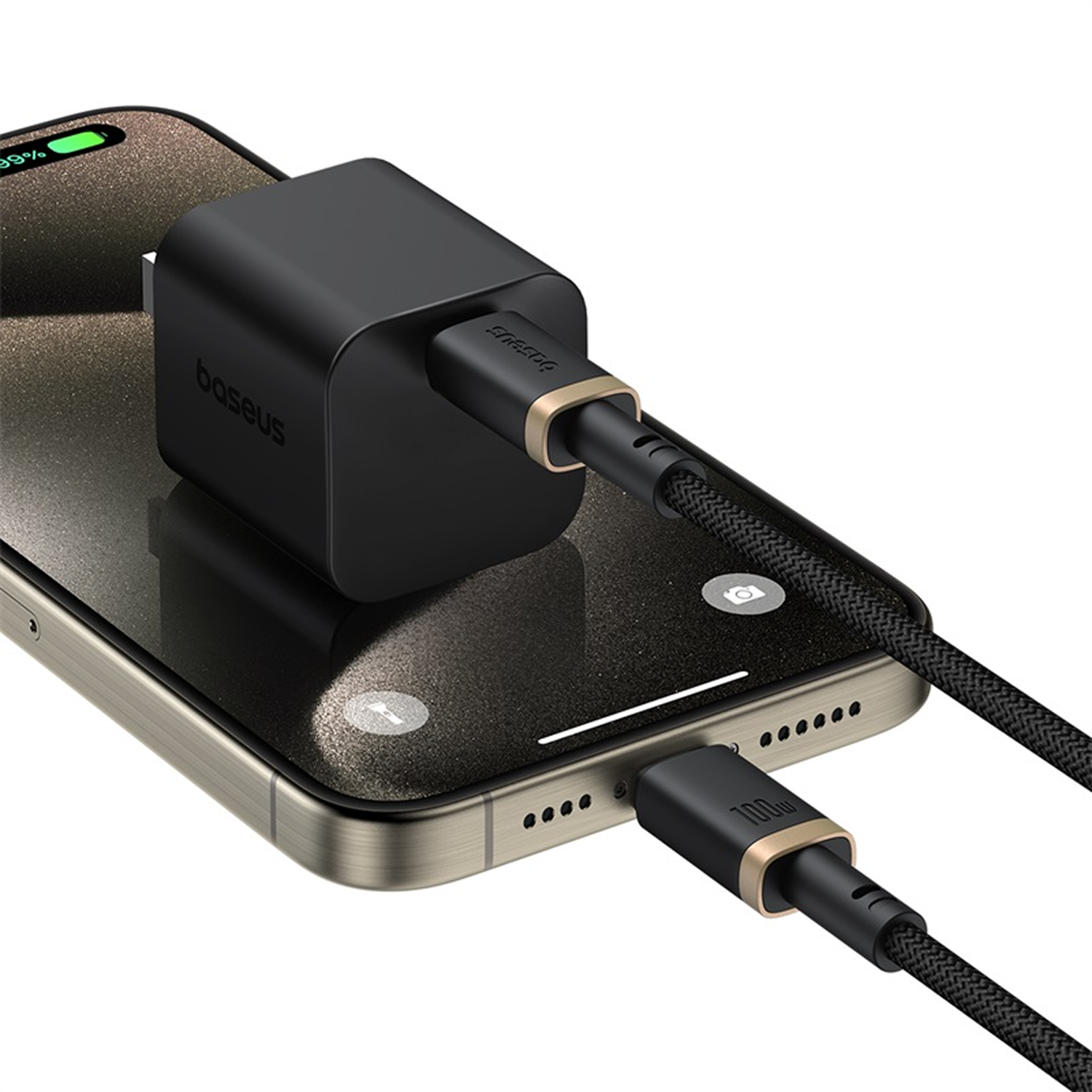 Un cargador Baseus negro está conectado a un teléfono. El teléfono muestra un 99% de carga. Un cable negro y dorado está conectado.