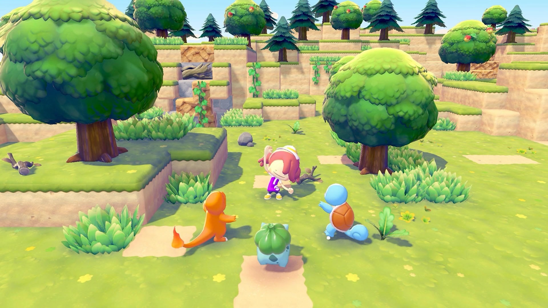 Eine Zeichentrickszene mit einer Person und drei Pokemon auf einem grünen Feld. Bäume und Hügel sind im Hintergrund.