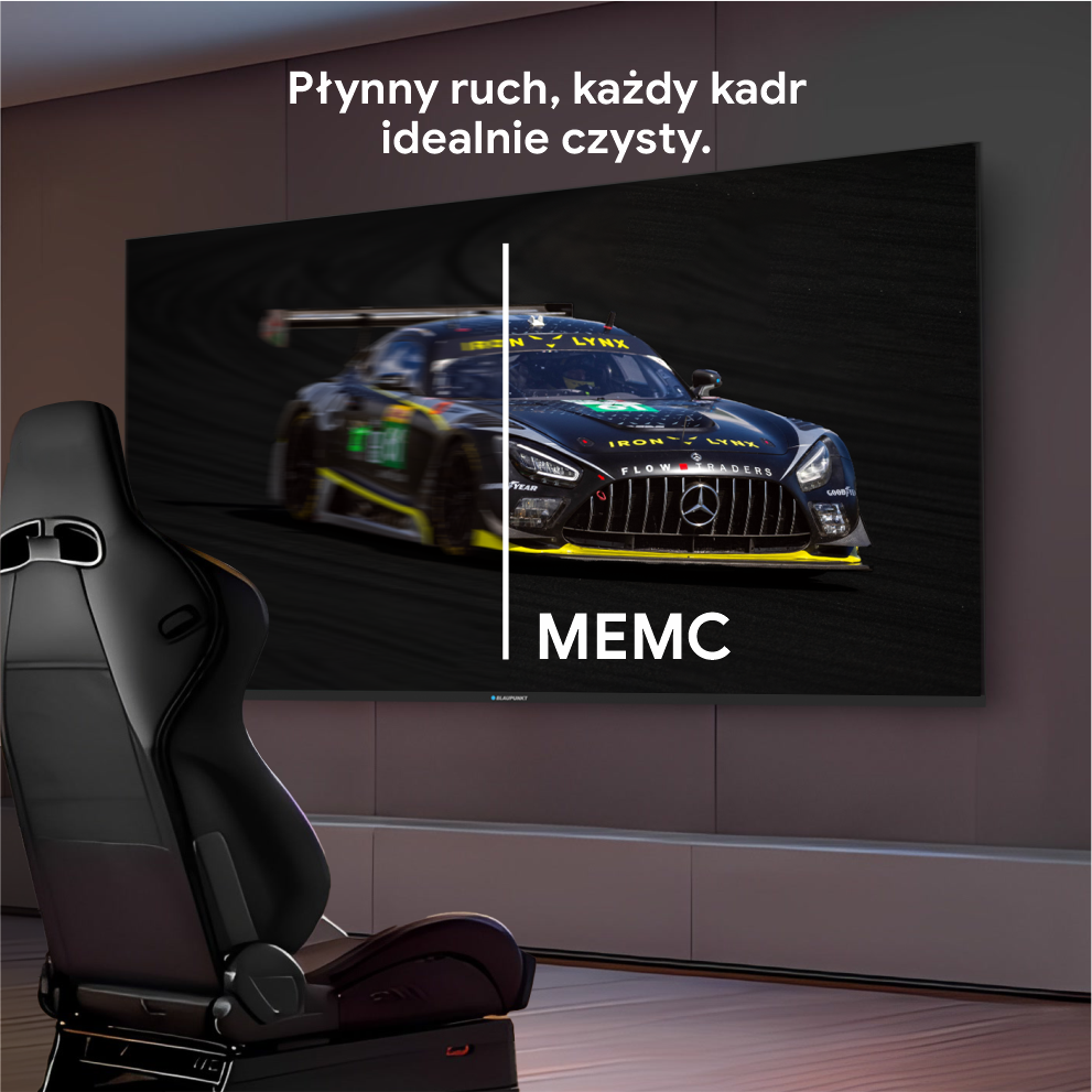 Czarny samochód wyścigowy na ekranie. Czarny fotel wyścigowy na pierwszym planie. Ekran pokazuje samochód jadący po torze.