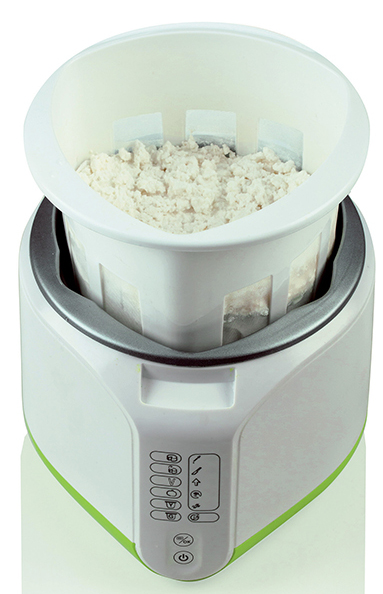 Białe i zielone urządzenie kuchenne z białą miską zawierającą białe jedzenie. Elementy sterujące znajdują się z przodu.